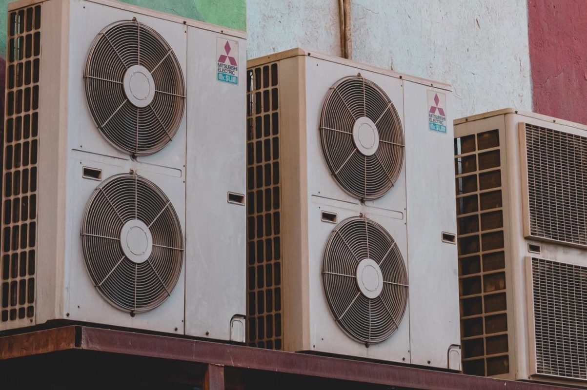 Two air conditioning cooling units along a wall.