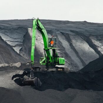 Crane moving piles of coal