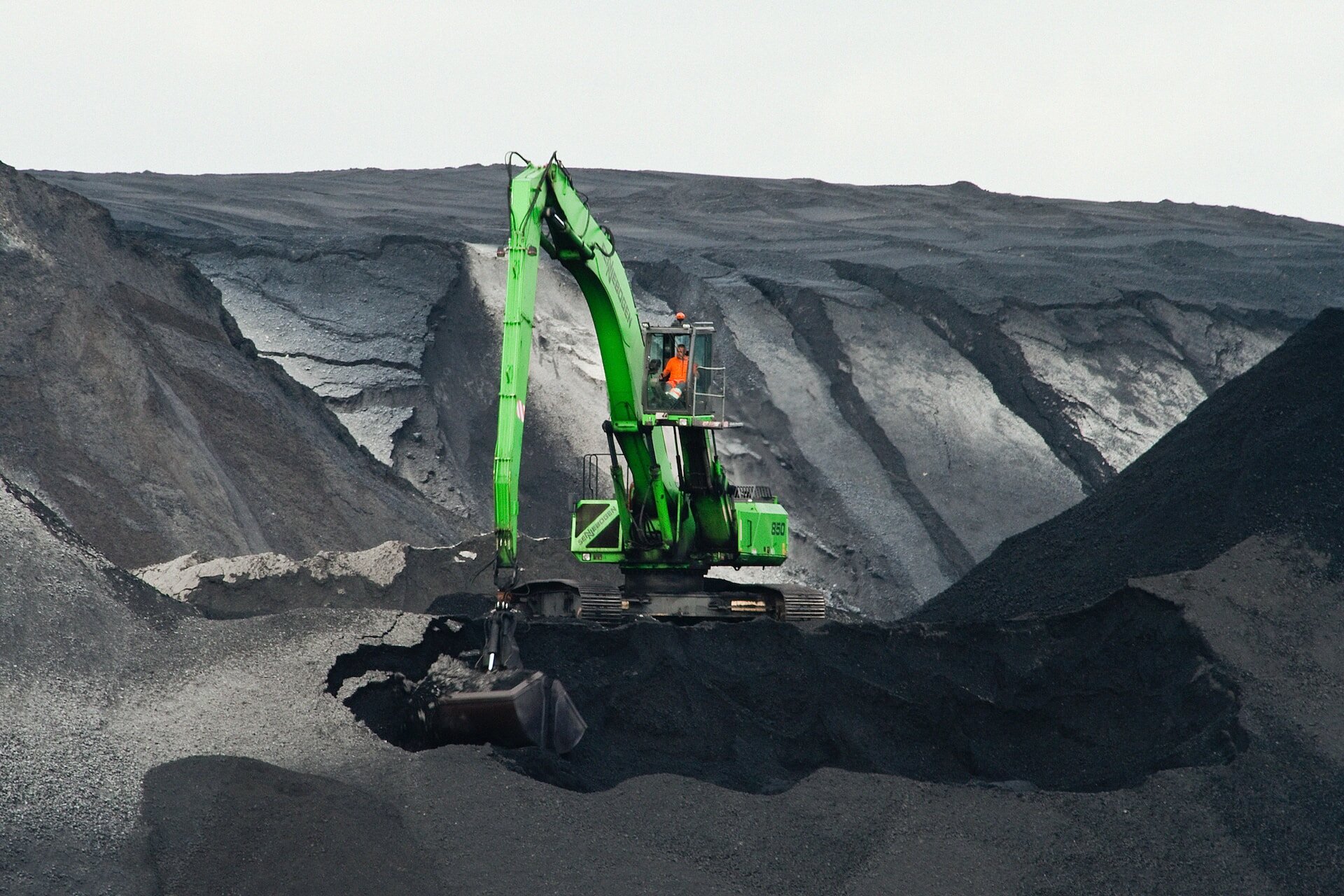 Crane moving piles of coal