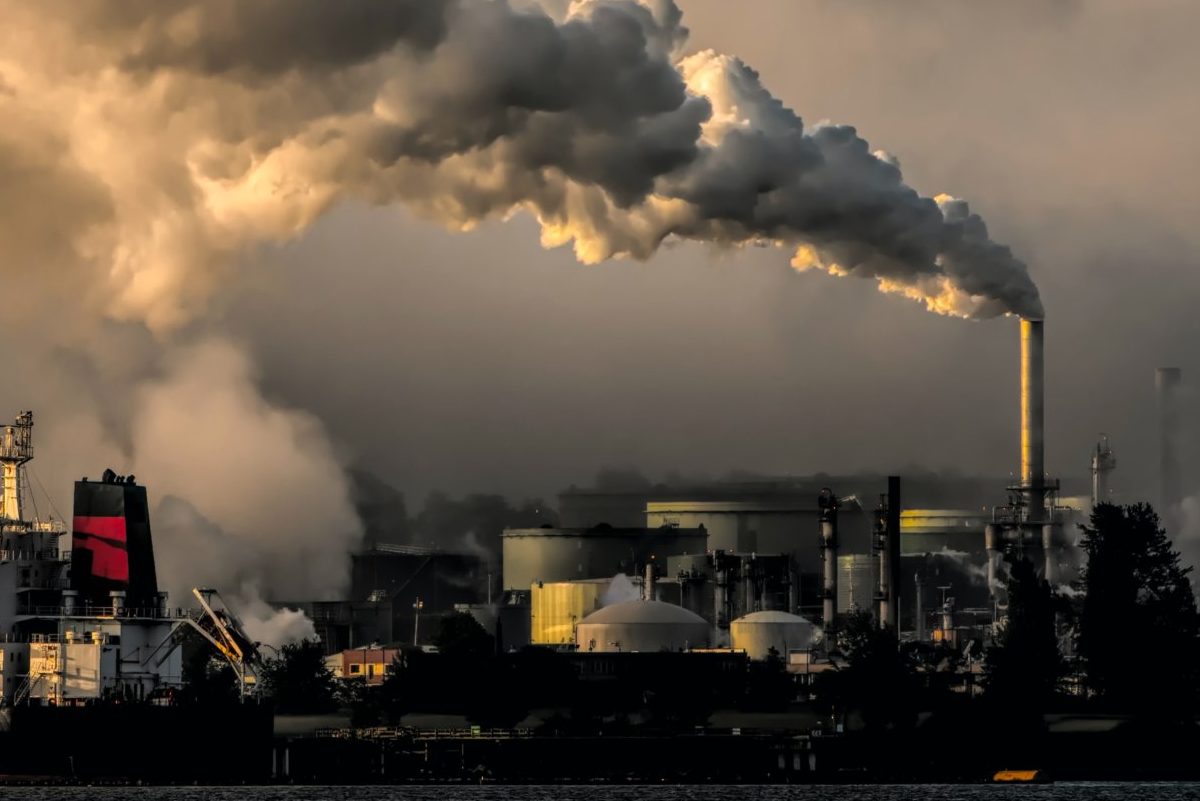 Landscape of ships and smoke coming out of an oil tanker